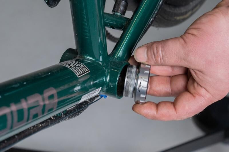 Lagerschale eines Gewindelagers wird in ein Tretlagergehäuse geschraubt.