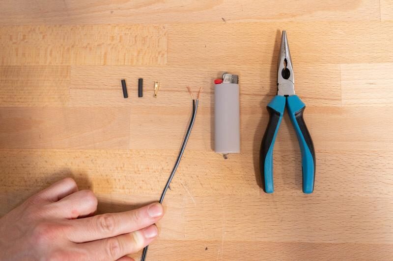 Briquet, gaine thermorétractable, fiche et pince, c'est tout ce dont tu as besoin pour remplacer un câble d'éclairage.