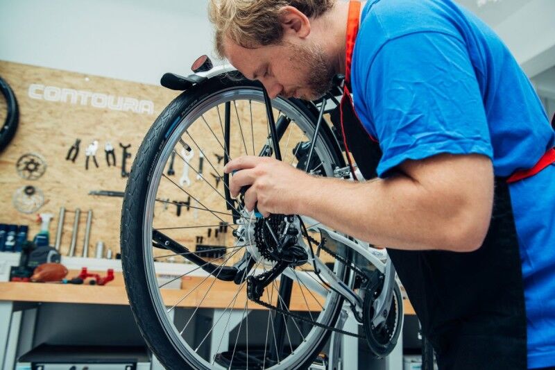  Une personne règle un dérailleur de vélo dans un atelier.